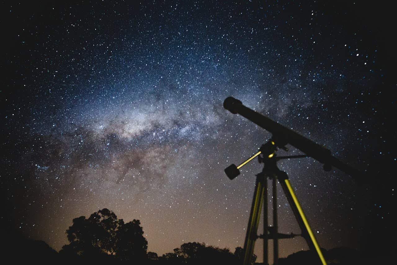 black telescope sitting in the ground