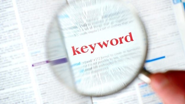 someone is searching competitors keyword with magnify glass where keyword red bold color