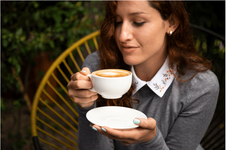 a woman has a cup in her hand and trying to drink coffee.